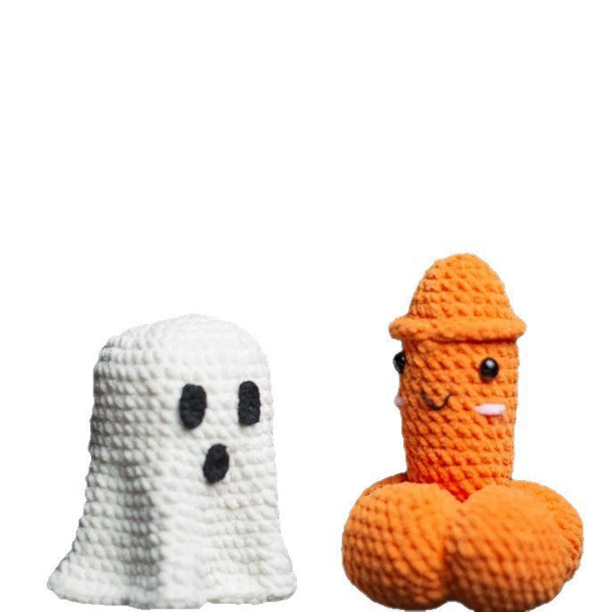 White crochet Halloween ghost next to a funny orange penis-shaped crochet novelty decoration with a smiling face on a plain white background.