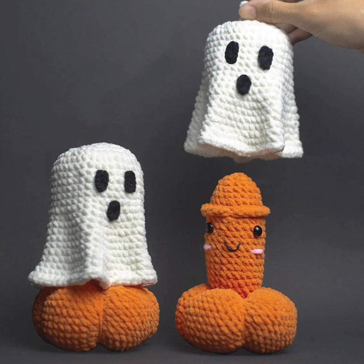 Funny crochet Halloween decorations featuring a white ghost and cheeky orange pumpkin-shaped novelty figure on a dark background.